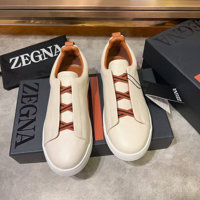 Ermenegildo Zegna 杰尼亚 光滑皮革 Tiziano 低帮运动鞋 这款tiziano 低帮运动鞋摔花纹牛皮制成，饰以丰富的工艺细节，如骆马红棕色