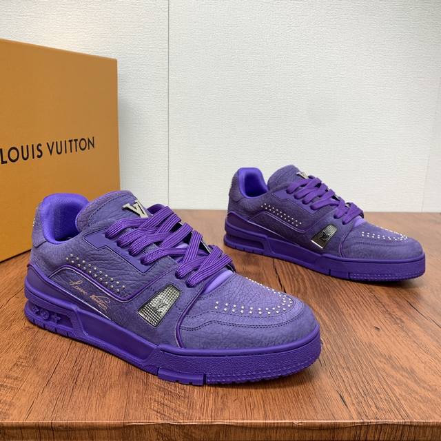 新款lv Trainer 男士运动鞋出货本款 Lv Trainer 运动鞋为粒面牛皮革渲染缤纷色调，鞋面点缀铆钉装饰，侧面点缀手写体路易威登标识，与后部西部风格