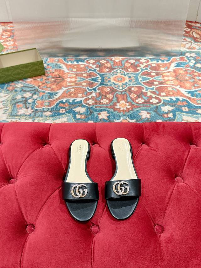 Gucci 2025春夏新款露趾凉鞋拖鞋每个细节皆经过精心细致打造，巧妙运用圆头和粗跟等设计元素演绎时尚复古风范。典藏的双G镶钻扣细节令人联想起品牌的时尚气息浓