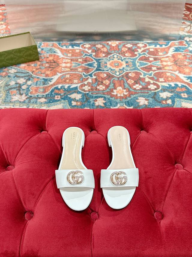 Gucci 2025春夏新款露趾凉鞋拖鞋每个细节皆经过精心细致打造，巧妙运用圆头和粗跟等设计元素演绎时尚复古风范。典藏的双G镶钻扣细节令人联想起品牌的时尚气息浓